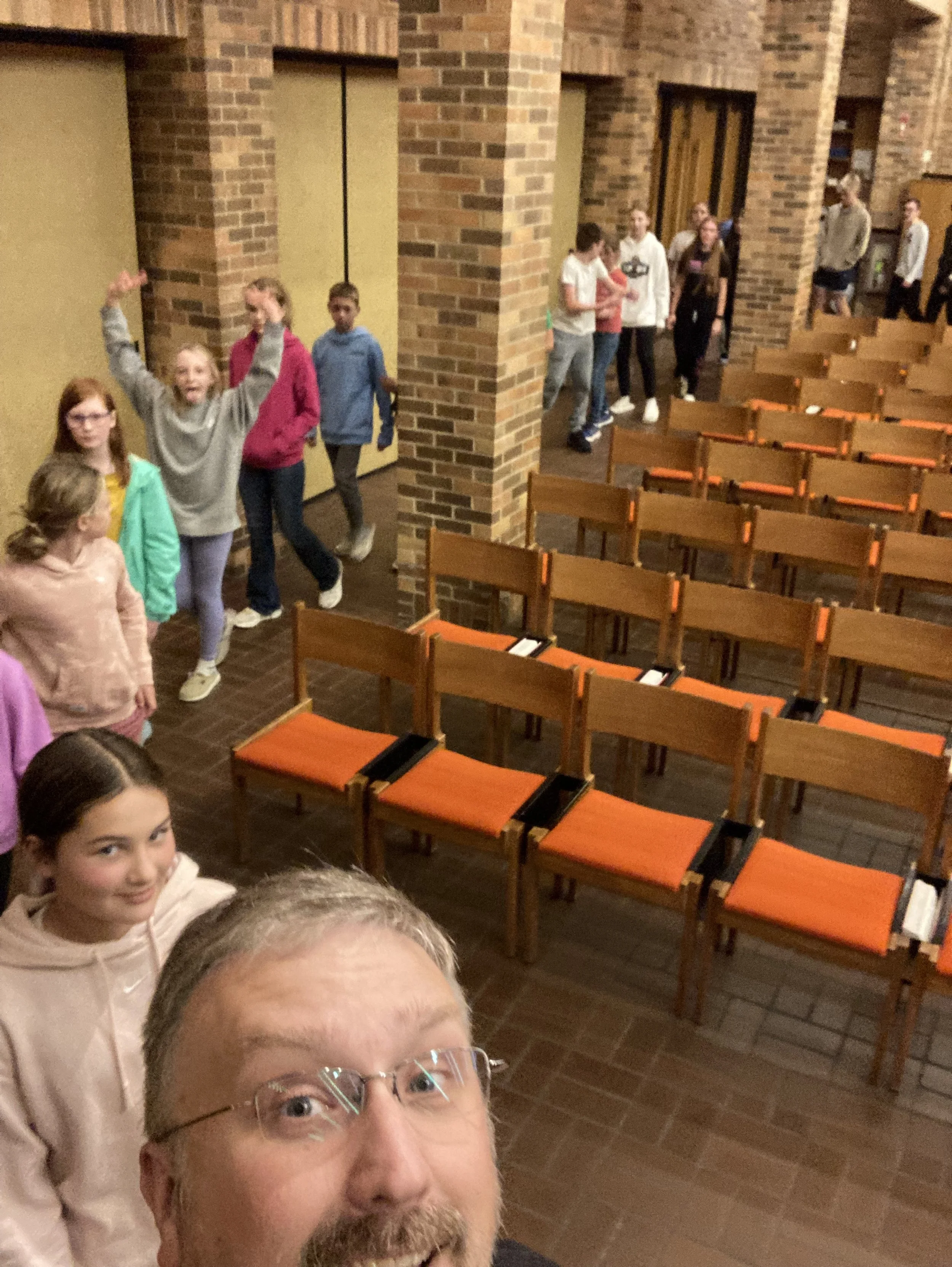 Pastor Ted leading confirmation students in a line around the sanctuary