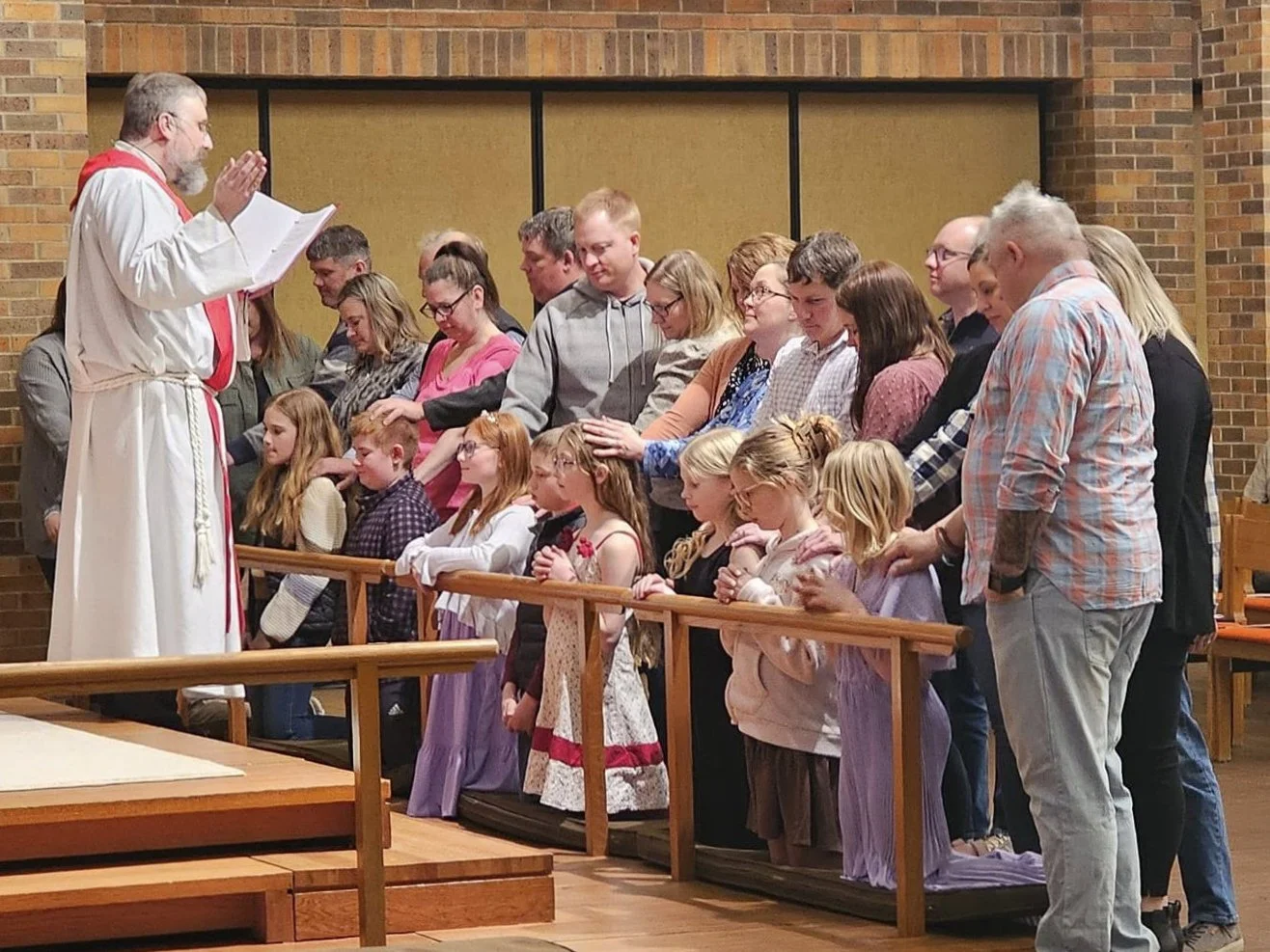 Fifth graders at Our Savior’s receiving a blessing as they receive their First Communion.